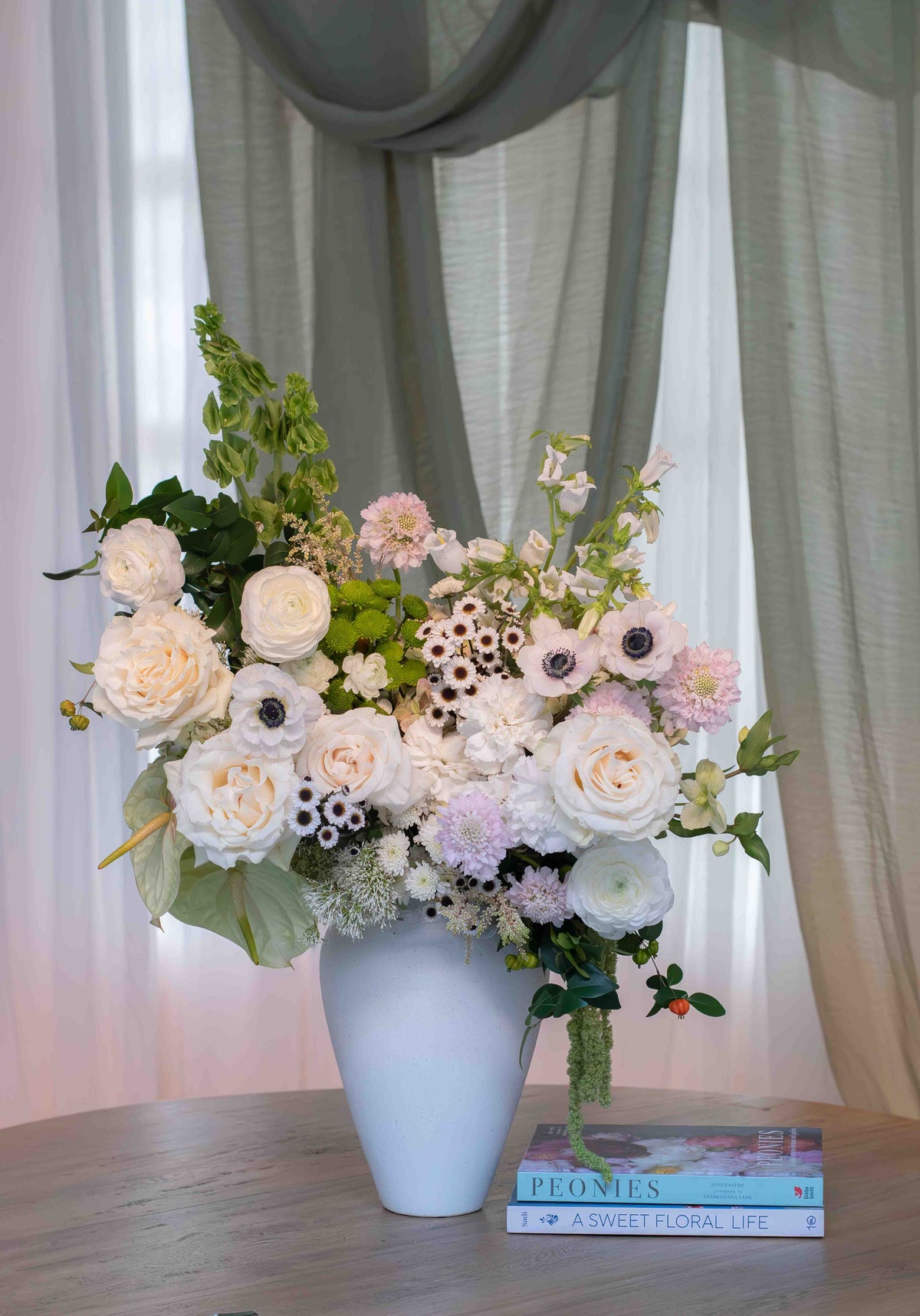Aura Serena, arreglo floral en florero de cerámica blanca con rosas de lujo y anémonas, Clementina Medellín