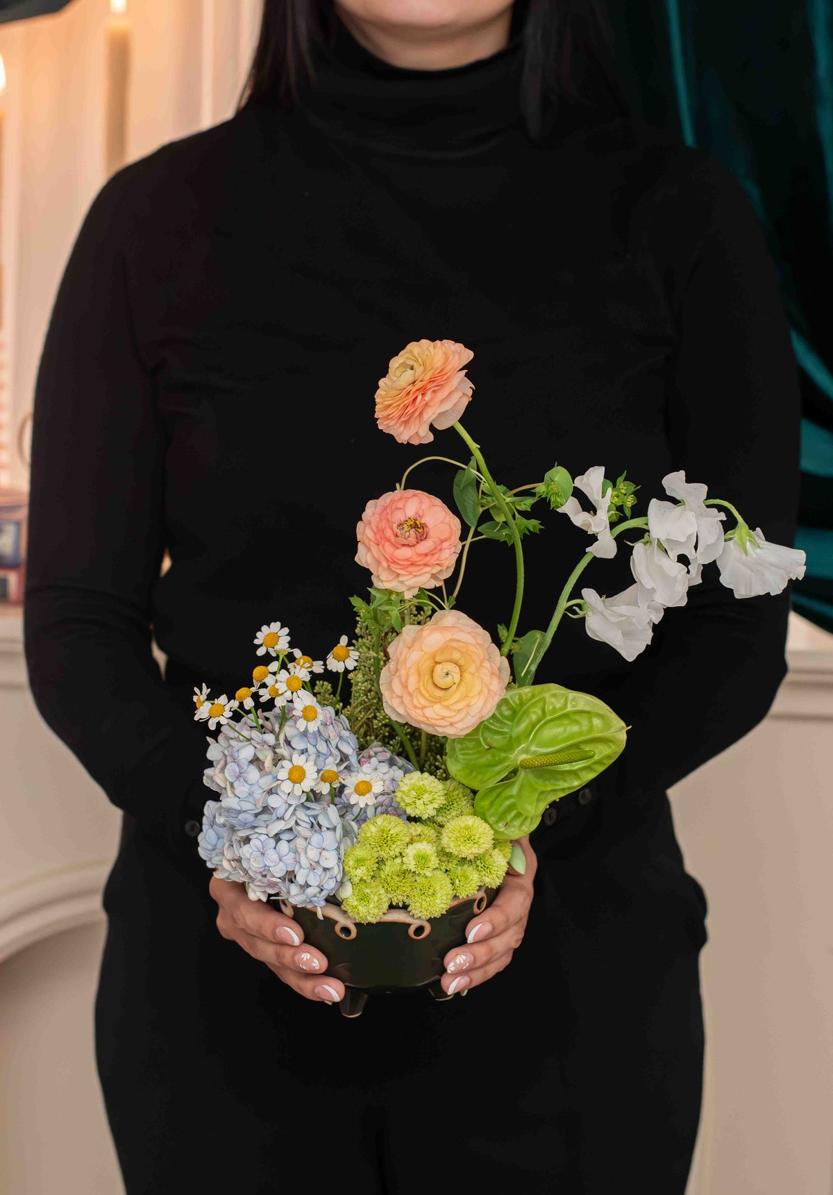 Jardín de Encantos en manos, hortensia azulada, ranúnculos y anturio verde en maceta de cerámica, Les Petits de Clementina Estudio Floral Medellín